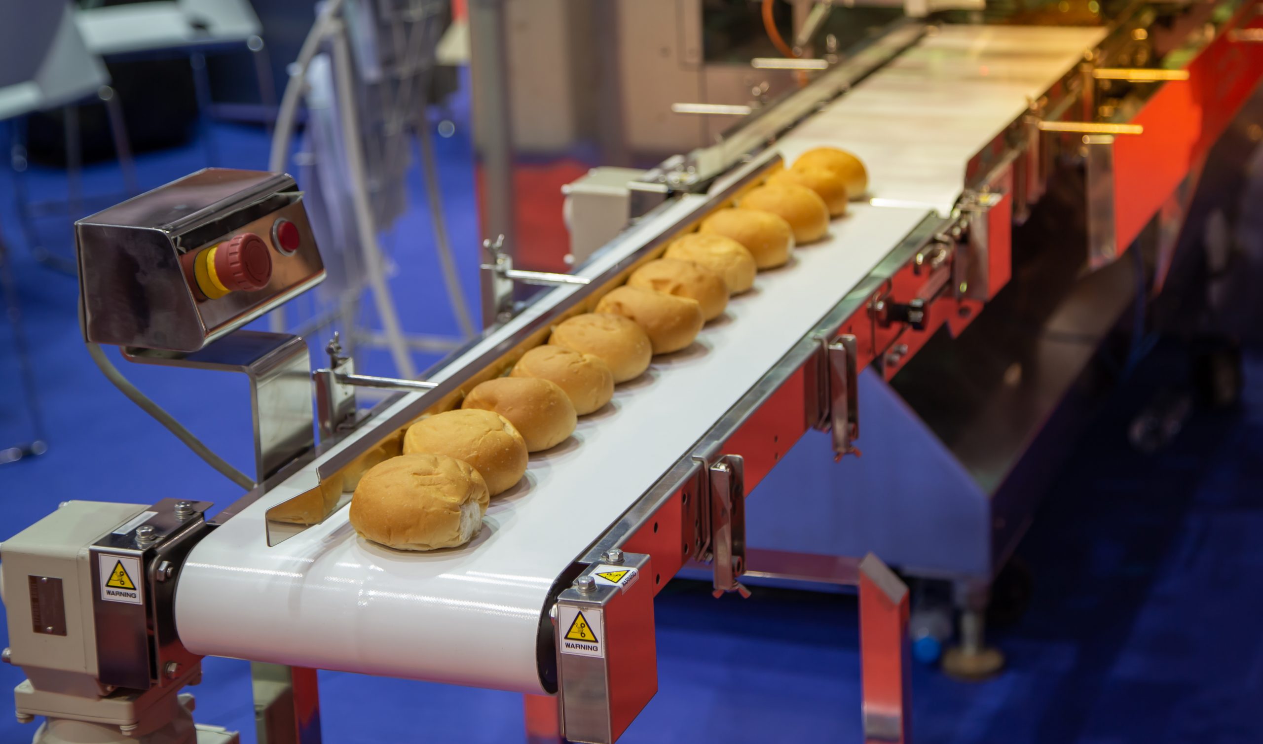 Buns,On,Conveyor,From,Bun,Making,Machine,In,Bakery,Factory